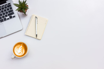 White office workspace with eye glasses,laptop,smart phone and cup of coffee.Top view with copy space.