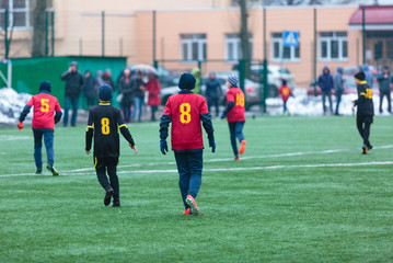 boys play football on the winter stadium