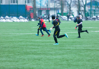 boys play football on the winter stadium