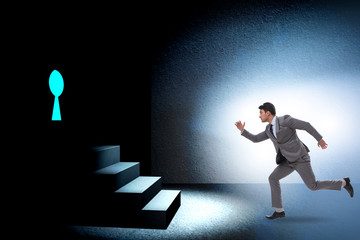Fototapeta premium Businessman walking towards keyhole in challenge concept
