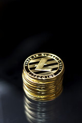 Shining golden litecoin coins on a dark background