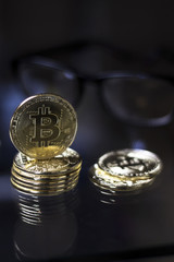 Golden bitcoin coins and eyeglasses