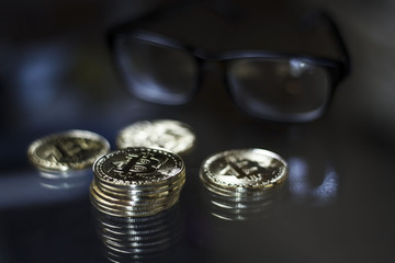 Golden bitcoin coins and eyeglasses