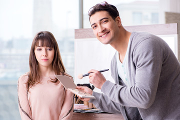 Man doing make-up for cute woman in beauty salon