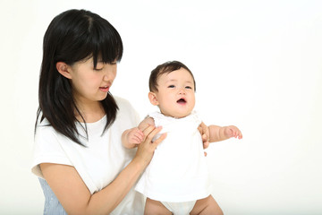 若いお母さんと遊ぶ笑顔の女の子の赤ちゃん