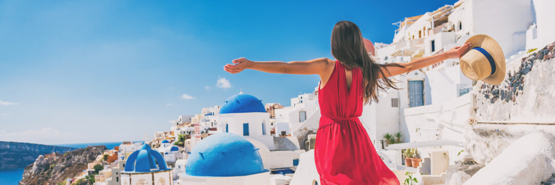 Fototapeta Europa podróż wakacje zabawa letnia kobieta czuje się swobodnie tańcząc z otwartymi ramionami na wyspie Oia, Santorini, Grecja. Beztroska dziewczyna panorama banner turystyczny.