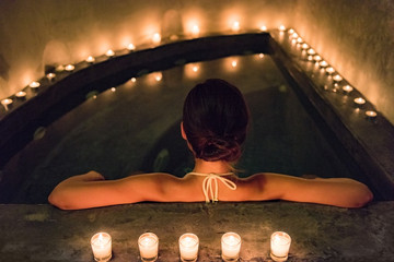 Spa luxury jacuzzi woman relaxing in whirlpool hot tub with water massaging jets. Woman in...