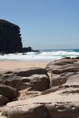 Fototapeta na wymiar Rocky outcrop at the beach on a sunny summer day