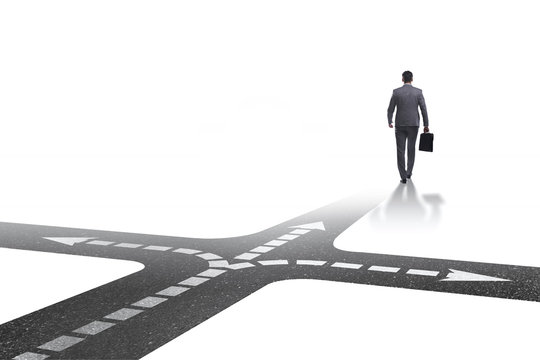 Young businessman at crossroads in uncertainty concept
