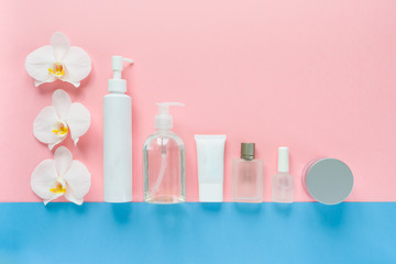 White cosmetic bottles on a pink and blue background. flat lay