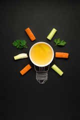 Fresh idea / Creative concept photo of plate with vegetables arranged as electric bulb on black background.
