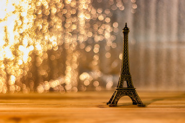 Eiffel model is placed on a wooden desk with a blurry background