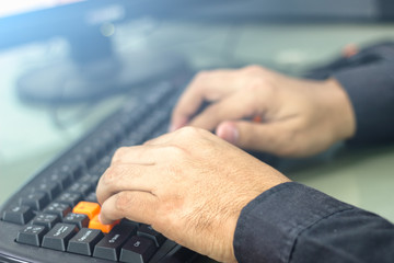 Businessman is working on a desktop computer on a desk.