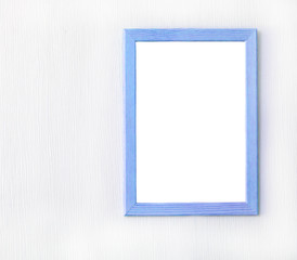Wooden frame with blank sheet of paper on light wall. Copy space. Mock up concept