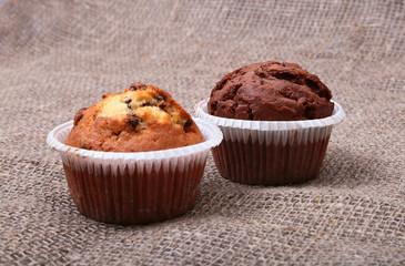 Fresh homemade muffins on Sackcloth woven texture background. Top view.