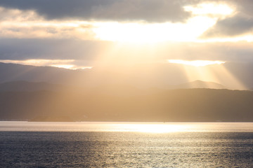 Stunning landscape sunrise  in the morning. Golden light go through the cloud to the mountain and sea.