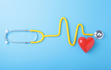 Red heart and a stethoscope on blue background