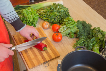 Chef cuts the vegetables into a meal. Preparing dishes. A Man uses a knife and cooks. Male's hands cutting bell pepper