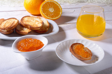 Naklejka na ściany i meble Morning Breakfast set with orange jam on bread toast and juice in glass.
