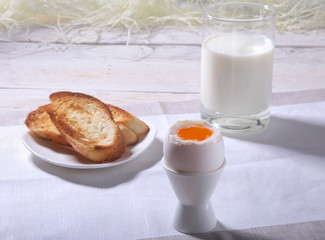 Morning Breakfast set with egg, orange jam on bread toast and milk in glass.