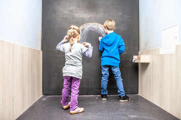 Boy and girl using chalkboard