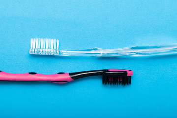 Two toothbrushes on a blue background.