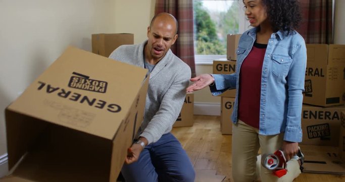 4K Stressed out couple arguing, preparing packing boxes during house move. Slow motion.