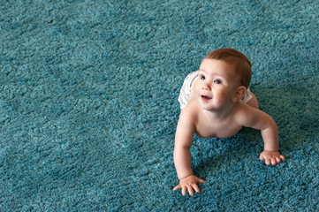 childhood, babyhood and people concept - hands of baby crawling on floor or carpet