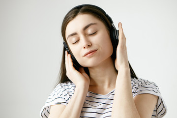 Music, meditation and relaxation concept. Studio shot of attractive brunette student girl posing...