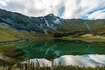 Fototapeta na wymiar Mountain lake with reflection of the sky and clouds