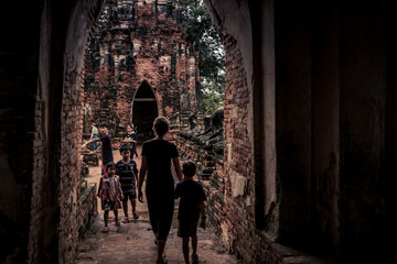 Fototapeta na wymiar Boy and mother walking in a buddhist templae, Ayutthaya