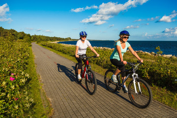 Obraz premium Women riding bicycles at seaside 