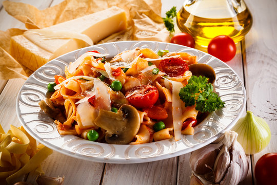 Pasta with vegetables on wooden background 