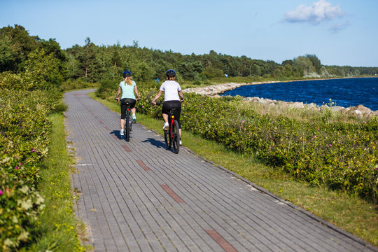 Women riding bicycles at seaside 