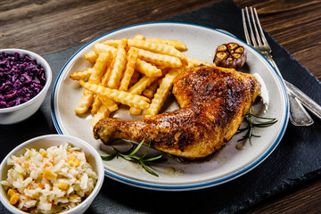 Grilled chicken legs with French fries and vegetables