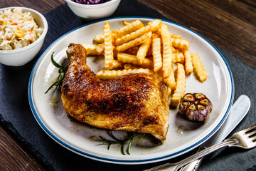 Grilled chicken legs with French fries and vegetables