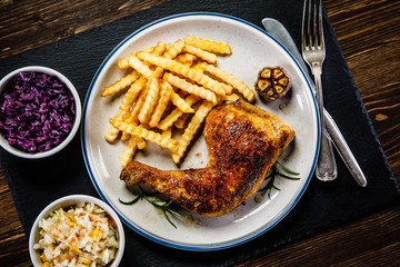 Grilled chicken legs with French fries and vegetables