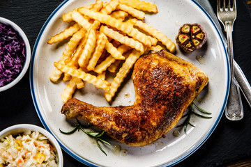 Grilled chicken legs with French fries and vegetables