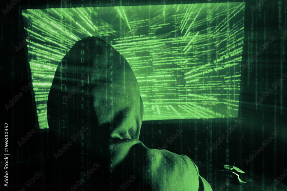 Poster a man hacker in a hood in a dark room works with the program code