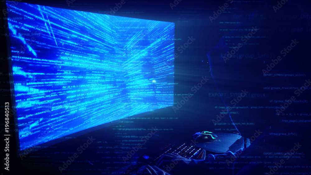 Poster a man hacker in a hood in a dark room works with the program code
