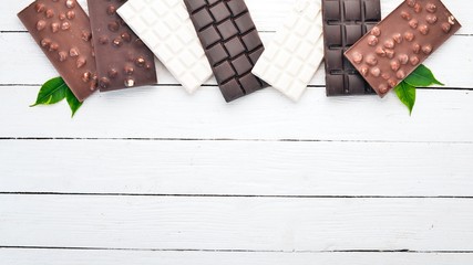 Dark and milky white chocolate on a wooden table. Top view. Copy space for text.