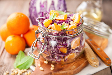 Red cabbage tangerines and pine nuts salad. Selective focus. Copy space.