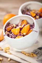Red cabbage tangerines and pine nuts salad. Selective focus. Copy space.