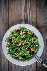 Fresh green salad with arugula, beets, walnuts and feta cheese
