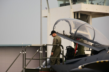 A fighter pilot standing next to his aircraft