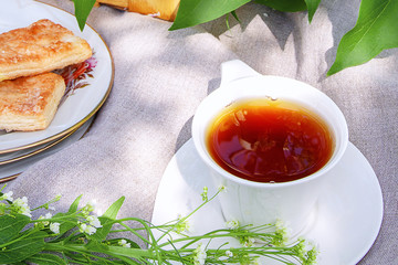 Picnic in nature with tea vypeskoy basket with flowers lilacs in a summer day in the park of life style