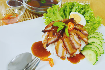 Barbecued red pork in sauce with rice.   
Thai Red BBQ Pork with Rice