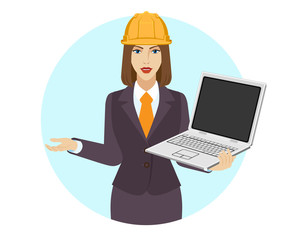 Businesswoman in construction helmet holding a laptop notebook and gesturing