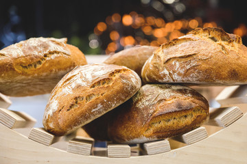 freshly baked bread and baked goods on the shelves on the counter of the bakery with beautiful bokeh in the background