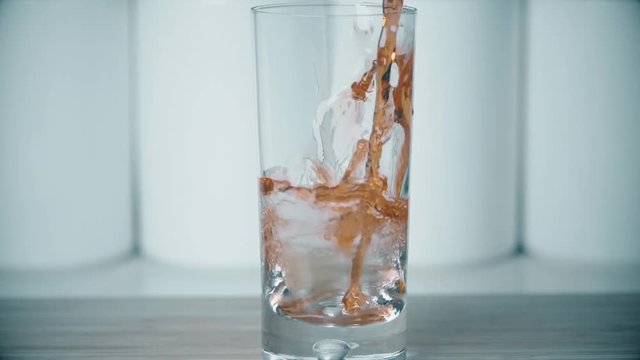 Pouring juice into glass, super slow motion shot